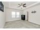 Bright bedroom featuring neutral carpet, a ceiling fan, and plenty of natural light from two windows at 11733 Mesquite Rd, Huntersville, NC 28078