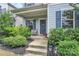 Inviting front porch featuring a cozy chair, potted plants, and decorative wreath on the front door at 11733 Mesquite Rd, Huntersville, NC 28078