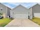 Two-car garage with carriage doors, decorative exterior lighting, and driveway at 11733 Mesquite Rd, Huntersville, NC 28078