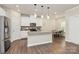 Modern kitchen features white cabinets, stainless steel appliances, and an island with pendant lighting at 11733 Mesquite Rd, Huntersville, NC 28078