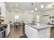 Open-concept kitchen featuring a large island, stainless steel sink, and a view of the dining area at 11733 Mesquite Rd, Huntersville, NC 28078