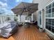 A backyard deck that is great for entertaining with an umbrella, fire pit, and cushioned seating at 1177 Triece Ln, Charlotte, NC 28215