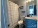 A clean full bath with a white sink, blue vanity, neutral shower curtain, and great lighting at 1177 Triece Ln, Charlotte, NC 28215