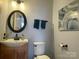 Cozy bathroom featuring a vanity sink and a stylish circular mirror at 1177 Triece Ln, Charlotte, NC 28215