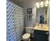 This full bathroom features a blue vanity, a toilet, and a shower with a decorative shower curtain at 1177 Triece Ln, Charlotte, NC 28215
