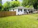 Charming single story home featuring a covered porch, dark shutters and wood fence at 1211 Campus St, Charlotte, NC 28216