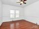 Bright bedroom featuring hardwood floors, ceiling fan and windows at 12300 Caldwell Rd, Charlotte, NC 28213