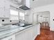 Bright modern kitchen boasts stone countertops, island cooktop, and under cabinet lighting at 12300 Caldwell Rd, Charlotte, NC 28213