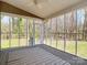 Enclosed patio featuring a ceiling fan and a pleasant view, ideal for relaxing and entertaining while enjoying nature at 12300 Caldwell Rd, Charlotte, NC 28213