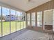 Screened-in patio, perfect for enjoying the outdoors with a stylish rug and a view of the well-maintained yard at 12300 Caldwell Rd, Charlotte, NC 28213