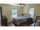 Cozy bedroom featuring hardwood floors, two windows and a ceiling fan at 1327 Mount Ulla Hwy, Mooresville, NC 28115