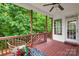 Inviting covered back porch with wood flooring and view of lush green trees and white trim at 136 Pink Orchard Dr, Mooresville, NC 28115