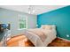 Bedroom with a teal accent wall, hardwood floors, and natural light from a large window at 136 Pink Orchard Dr, Mooresville, NC 28115