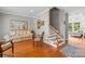 Cozy living room featuring hardwood floors and a charming staircase at 136 Pink Orchard Dr, Mooresville, NC 28115
