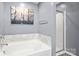 A clean bathroom features a white tub with marble backsplash and a glass-door shower stall at 1398 Kent Downs Sw Ave # 52, Concord, NC 28027