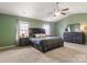 Spacious bedroom with vaulted ceiling, carpet flooring, complemented by a ceiling fan and natural light from multiple windows at 1398 Kent Downs Sw Ave # 52, Concord, NC 28027