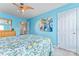A relaxing bedroom featuring blue walls, a ceiling fan, and a comfortable bed with colorful bedding at 1418 Skidaway Nw St # 427, Concord, NC 28027