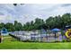 Resort style community pool and playground surrounded by trees at 1418 Skidaway Nw St # 427, Concord, NC 28027