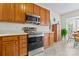 Well-lit kitchen with stainless steel appliances and wood cabinets next to a breakfast nook at 1418 Skidaway Nw St # 427, Concord, NC 28027