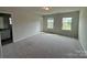 Inviting bedroom with plush carpeting, two bright windows, and neutral walls at 145 W Morehouse Ave, Mooresville, NC 28117