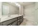 Bright bathroom features a double sink vanity, tile flooring, and a combined tub and shower unit at 14505 Rhodes Hall Dr, Charlotte, NC 28273