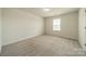 Bright, empty bedroom offers a clean and versatile space with natural light and neutral carpeting at 14505 Rhodes Hall Dr, Charlotte, NC 28273