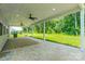 Spacious covered patio featuring a brick base, ceiling fans and a view of the lush backyard at 14505 Rhodes Hall Dr, Charlotte, NC 28273