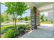 Inviting porch with stone columns, manicured shrubs and a view of the quiet, tree-lined street at 14505 Rhodes Hall Dr, Charlotte, NC 28273
