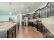 Modern kitchen with stainless steel appliances, granite countertops, dark wood cabinets and hardwood floors at 14505 Rhodes Hall Dr, Charlotte, NC 28273