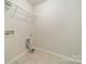 This laundry room offers essential hookups with tile flooring and wire shelving at 14505 Rhodes Hall Dr, Charlotte, NC 28273