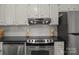 A close up of a modern stainless steel range and hood set against white subway tile and black countertops at 146 Duff St, Gastonia, NC 29715