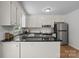 A well-lit kitchen featuring white cabinets, stainless steel appliances, and black countertops at 146 Duff St, Gastonia, NC 29715