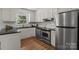 A well-lit kitchen featuring white cabinets, stainless steel appliances, and black countertops at 146 Duff St, Gastonia, NC 29715