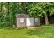 A backyard shed surrounded by lush greenery and landscaping at 146 Duff St, Gastonia, NC 29715
