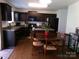 Traditional kitchen with dark cabinetry, an island, and an adjacent dining area with wood table and chairs at 1818 Windy Willow Ln, Dallas, NC 28034