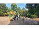 Colorful community playground featuring slides, climbing structures, and ample space for children to play, nestled in a wooded area at 1818 Windy Willow Ln, Dallas, NC 28034