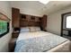 Comfortable RV bedroom with a queen-size bed, overhead storage, and a window for natural light at 207 Cardinal Dr, New London, NC 28127