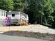Charming RV parked on a well-maintained lot with landscaped gravel, offering a serene getaway at 207 Cardinal Dr, New London, NC 28127