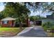 View of a charming red brick home with an adjacent detached garage and storage shed at 208 S Thompson St, Monroe, NC 28112