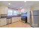 Well-lit kitchen featuring stainless steel appliances and white cabinetry at 208 S Thompson St, Monroe, NC 28112