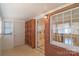 Bright sunroom featuring brick accents, built-in shelving, a tile floor, and a view to the kitchen at 208 S Thompson St, Monroe, NC 28112