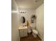 Cozy bathroom with an oval mirror, wood-look flooring, and a decorative shelf at 212 E Texas Ave, Bessemer City, NC 28016