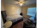 Bedroom with wood floors, ceiling fan, a bed with a gray blanket, and a window at 212 E Texas Ave, Bessemer City, NC 28016