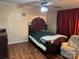 A bedroom with wood-look flooring, a ceiling fan, a window, and a bed at 212 E Texas Ave, Bessemer City, NC 28016