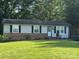 Charming single-story home with a brick foundation and light-colored siding, surrounded by mature trees at 212 E Texas Ave, Bessemer City, NC 28016