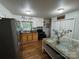 An eat-in kitchen features updated appliances, wood cabinets and flooring, and dining area at 212 E Texas Ave, Bessemer City, NC 28016