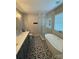 Spacious bathroom with a freestanding tub, glass-enclosed shower, and patterned tile flooring at 21218 Baltic Dr, Cornelius, NC 28031