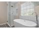 Bathroom featuring a soaking tub and a glass-enclosed shower with subway tile at 21218 Baltic Dr, Cornelius, NC 28031