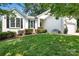 A quaint white home with black shutters, trimmed bushes and a manicured front lawn at 21218 Baltic Dr, Cornelius, NC 28031