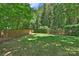 Spacious backyard featuring a lush lawn, privacy fence, and mature trees, creating a serene outdoor space at 2223 Club Rd, Charlotte, NC 28205